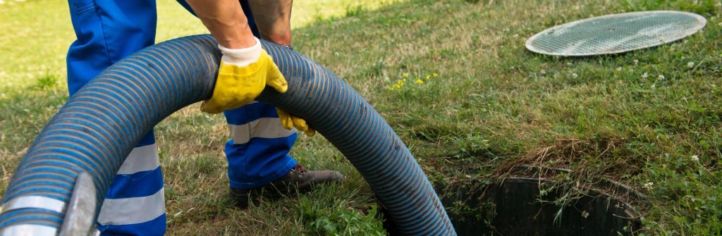 Septic service technician pumping a residential septic tank